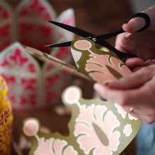 Load image into Gallery viewer, Person cutting a piece of floral-patterned paper with scissors