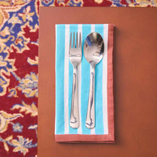 Load image into Gallery viewer, Silver fork and spoon on a striped napkin against a floral-patterned background