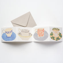 Load image into Gallery viewer, A card that unfolds to reveal four beautifully illustrated cups and saucers.