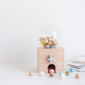 Wooden toy with a transparent dome containing colorful beads on a white background