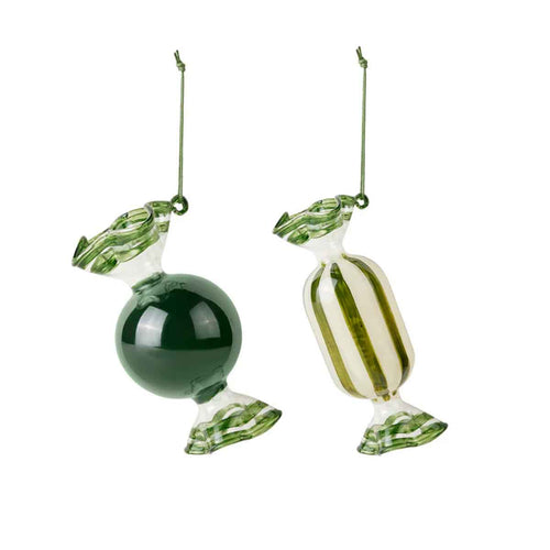 Two glass candy ornaments, one green sphere and one striped candy, on a white background.