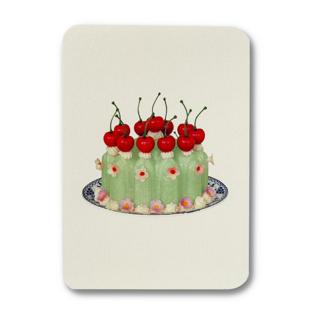 Green cake with red cherries on a white background