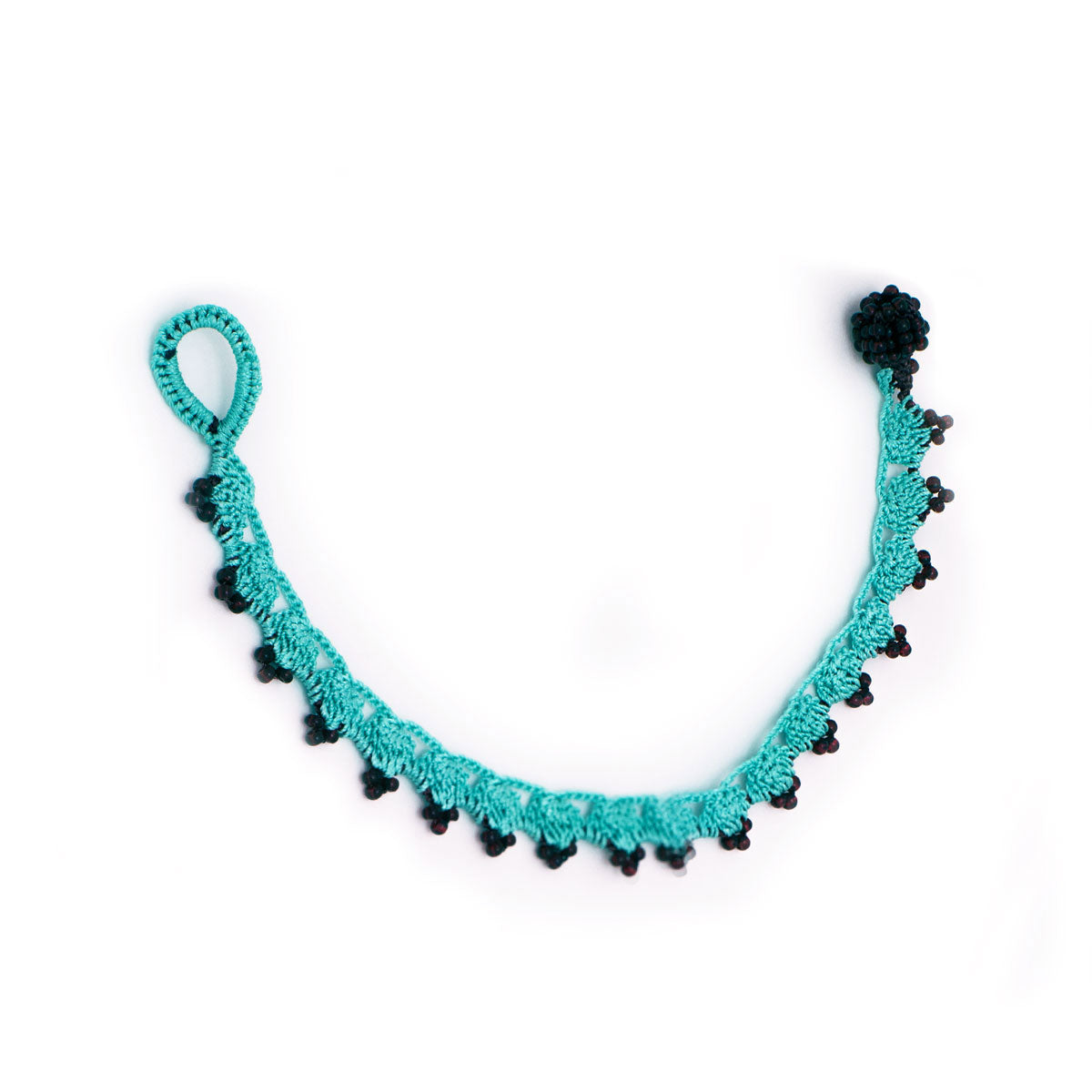 Bracelet with turquoise  and  dark red beads on white background