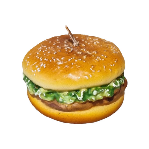 Burger-shaped candle with sesame seed bun on a white background