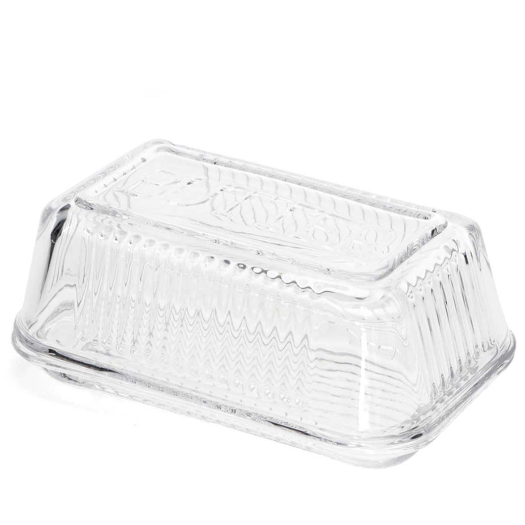 Clear glass butter dish with lid on a white background