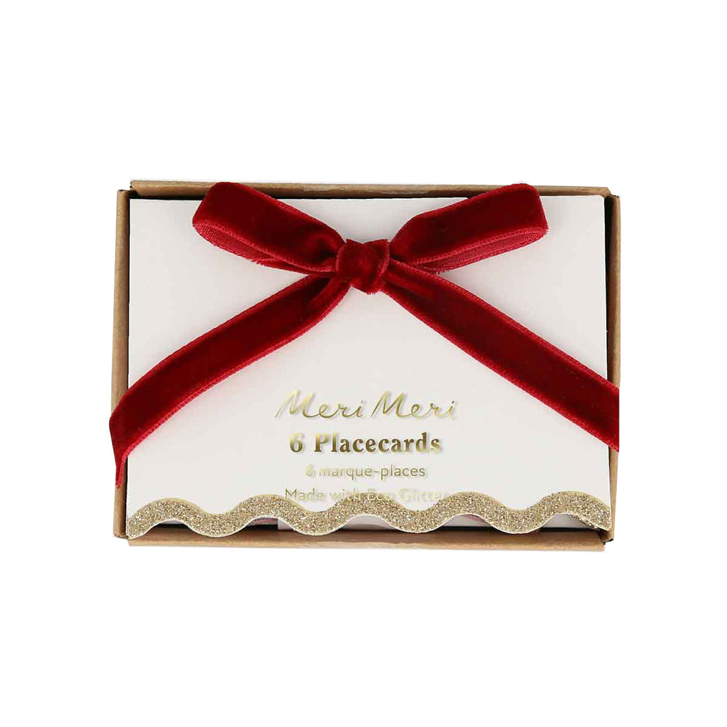 Box of Meri Meri placecards with a red ribbon on a white background