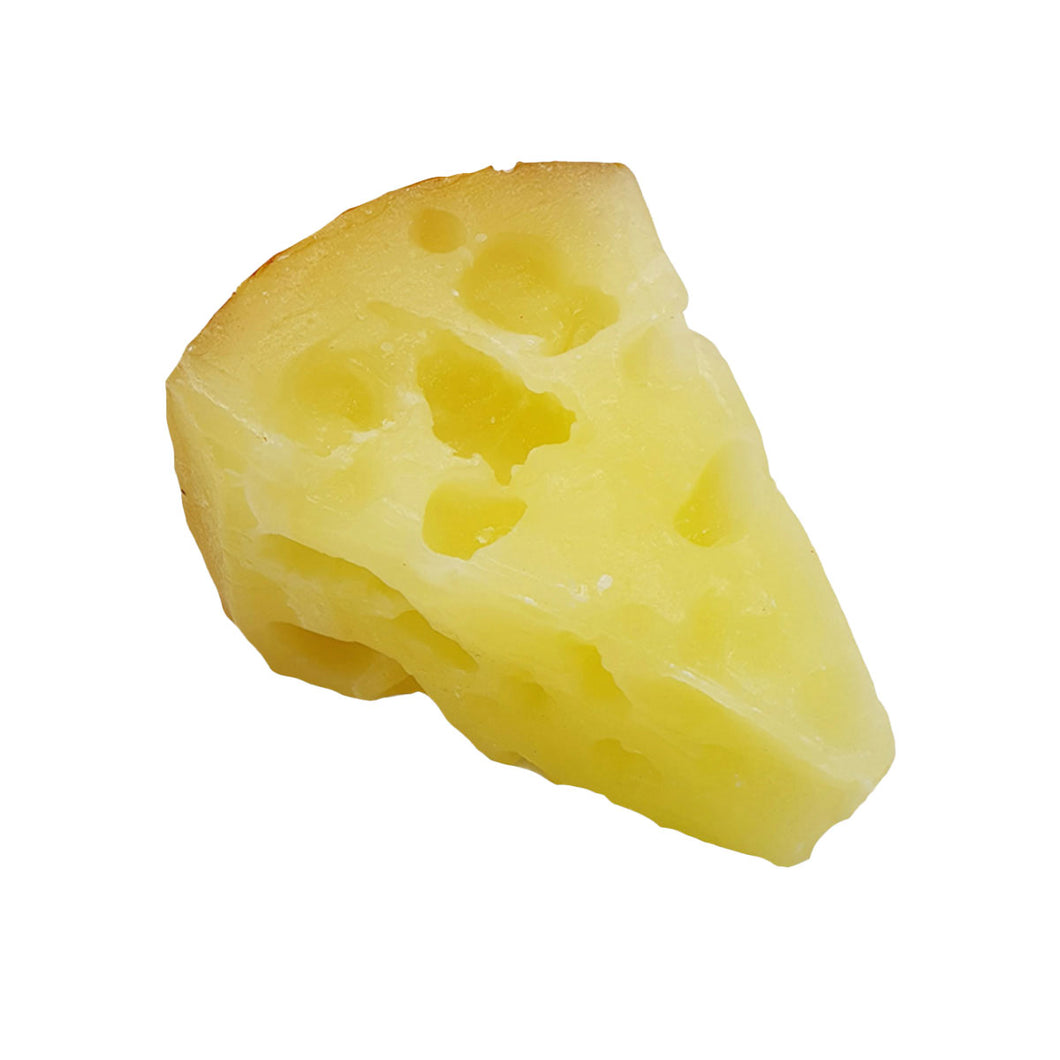 Candle shaped as a block of cheese on a white background