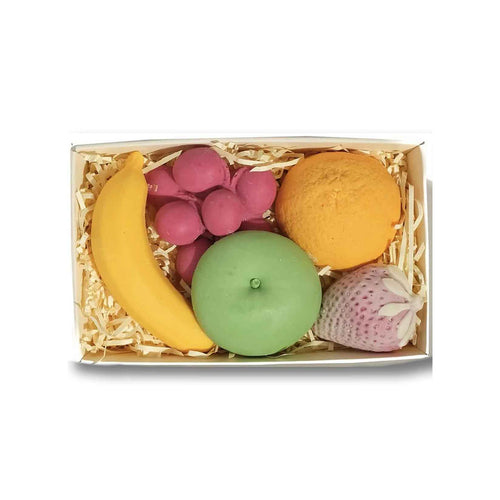 Box of colorful fruit-shaped candles on a white background