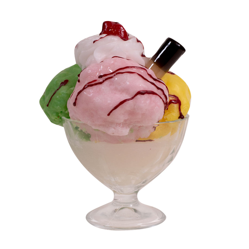 Candle shaped as a glass bowl with colorful ice cream and a cherry on top against a white background