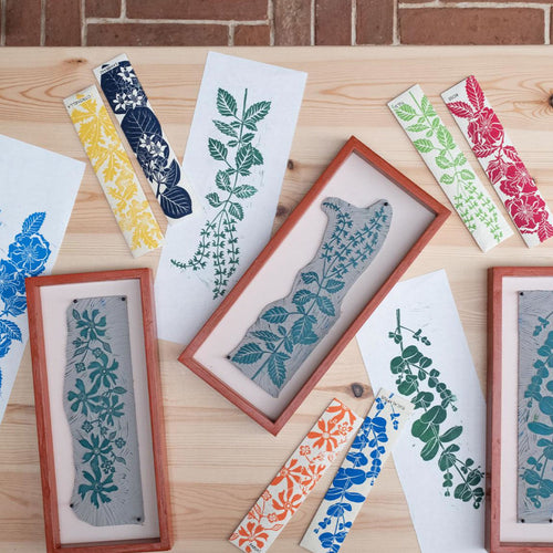 Decorative bookmarks with floral and geometric patterns on a wooden surface.