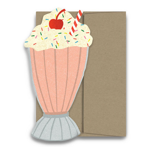 Card with a design of a pink milkshake with whipped cream, cherry, and straws on a brown card.